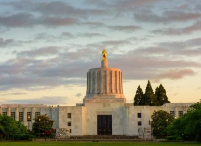 The Oregon State Capitol Building under a cloudy sky at sunset.